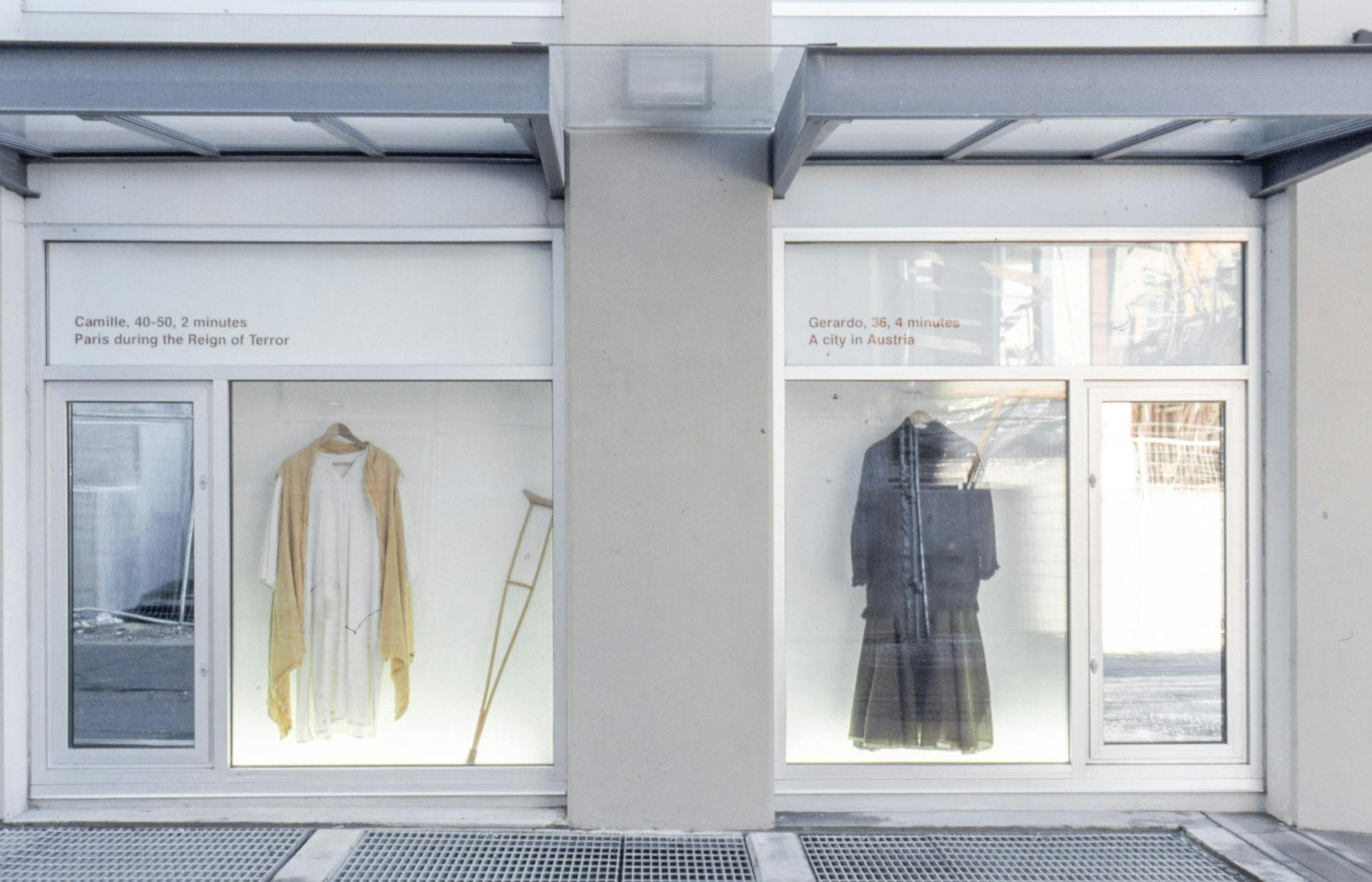Various outfits are displayed in CAG’s window spaces. Above the installation of a dark-coloured outfit, there is a red text that says “The Gerardo 36, 4 minutes, A city in Austria.” 